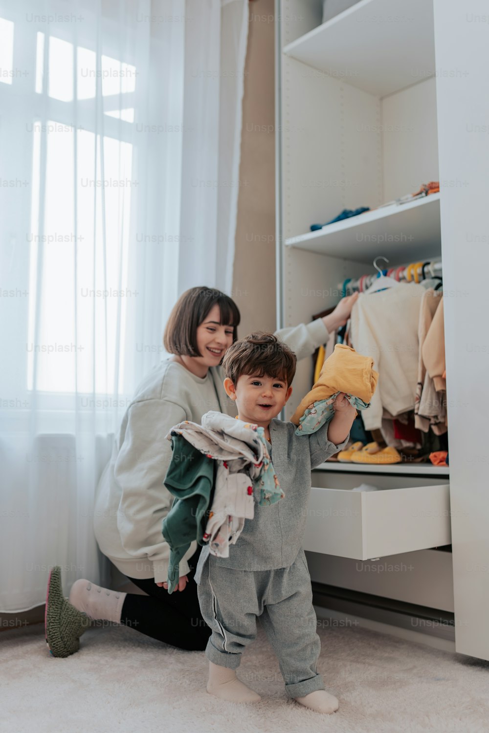 a woman and a child standing in front of a closet