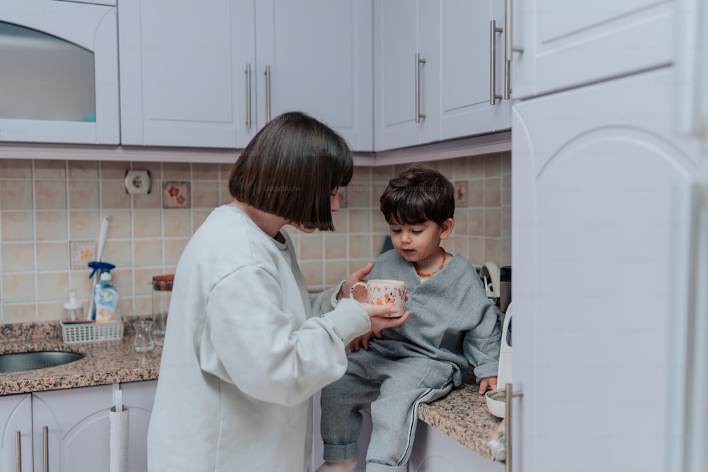 una mujer con bata blanca y un niño en una cocina