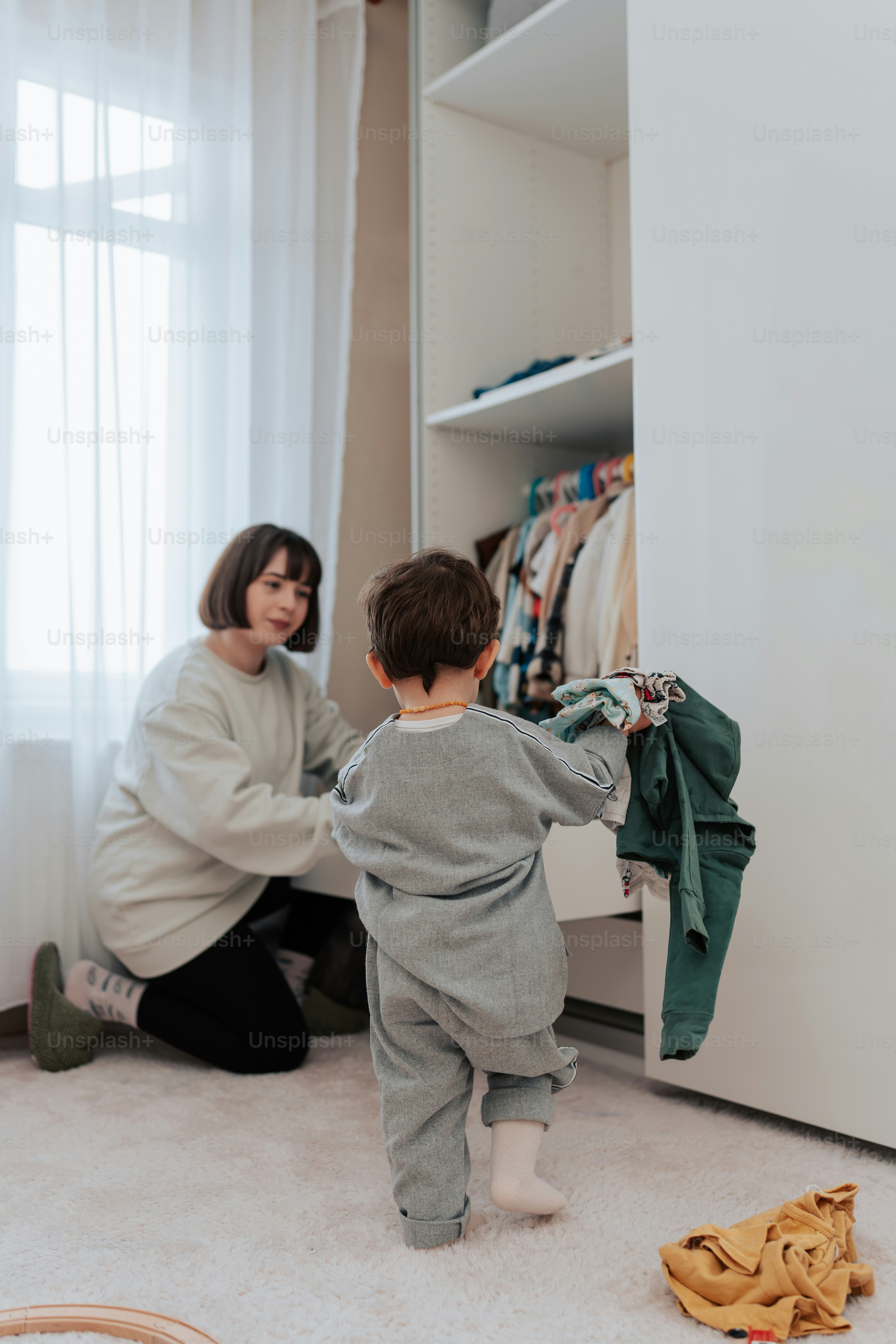 a woman kneeling down next to a child