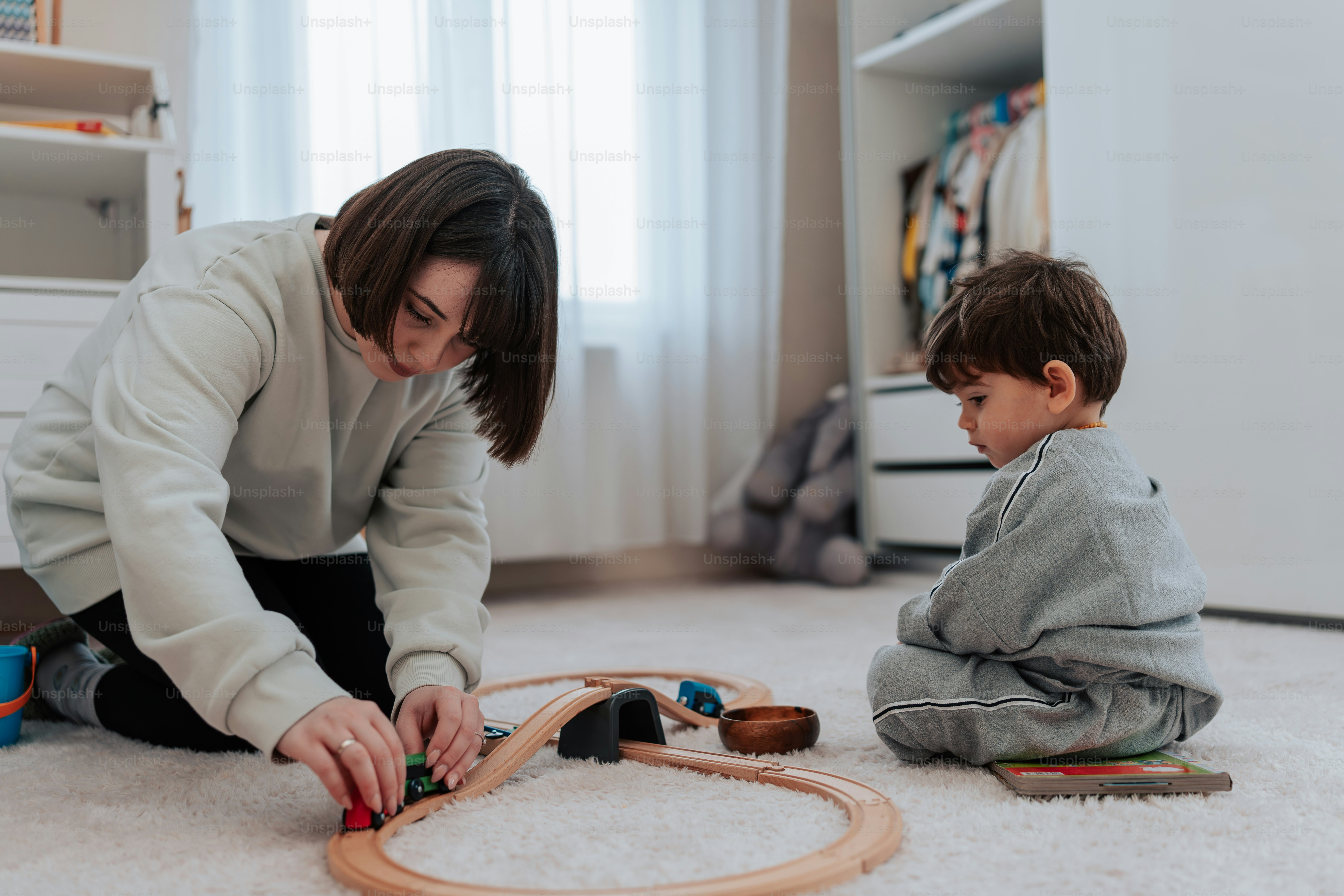 a woman playing with a child on the floor