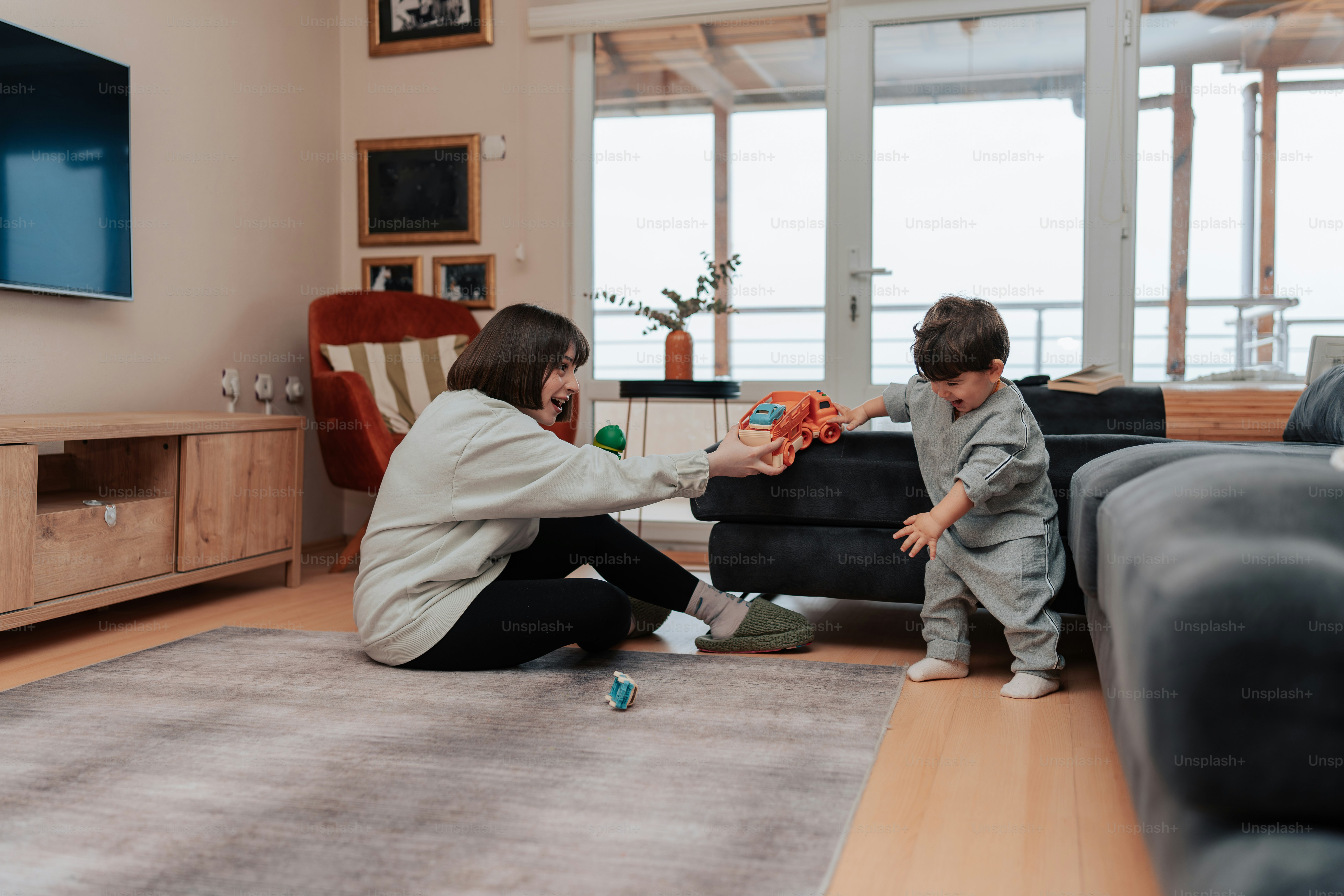 a woman playing with a child in a living room