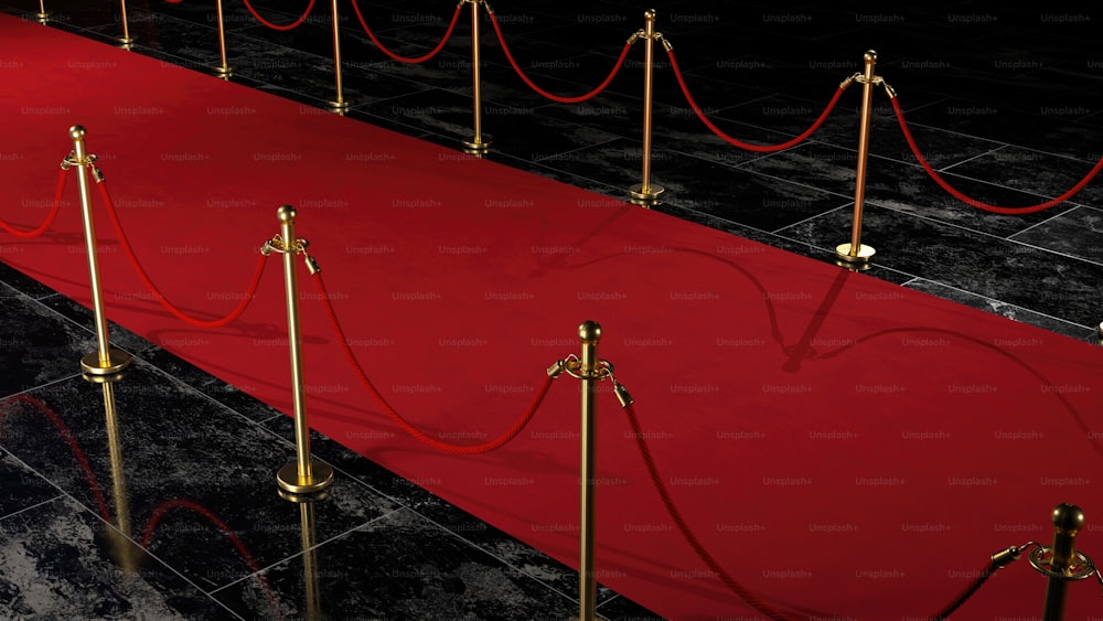 a red carpet with gold barriers and ropes