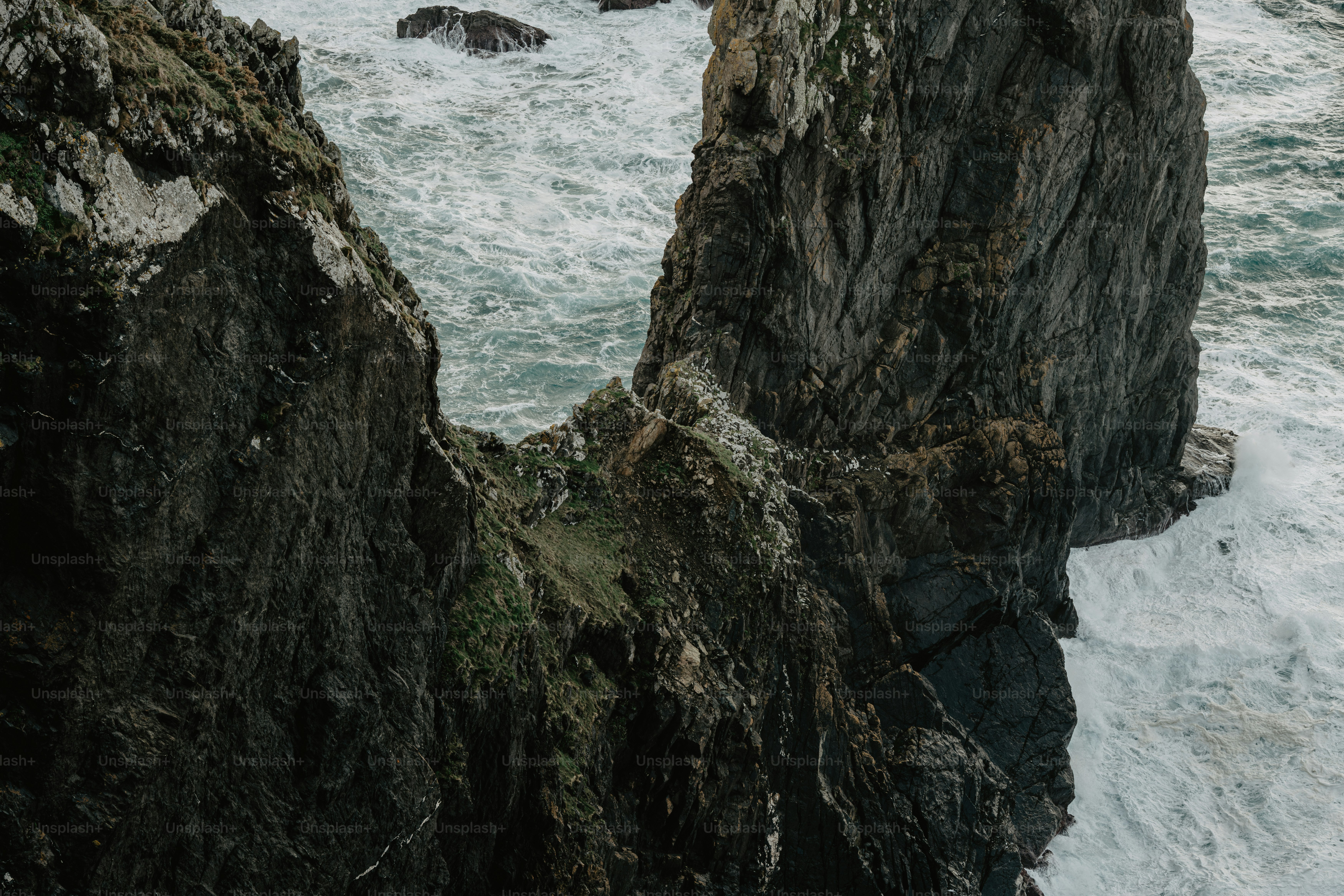 a person standing on a cliff near the ocean