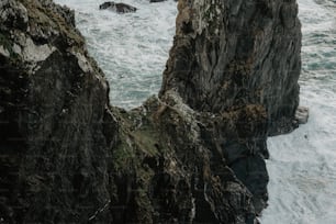 Una persona parada en un acantilado cerca del océano