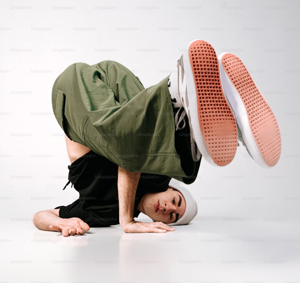 a man doing a handstand with his feet on the ground