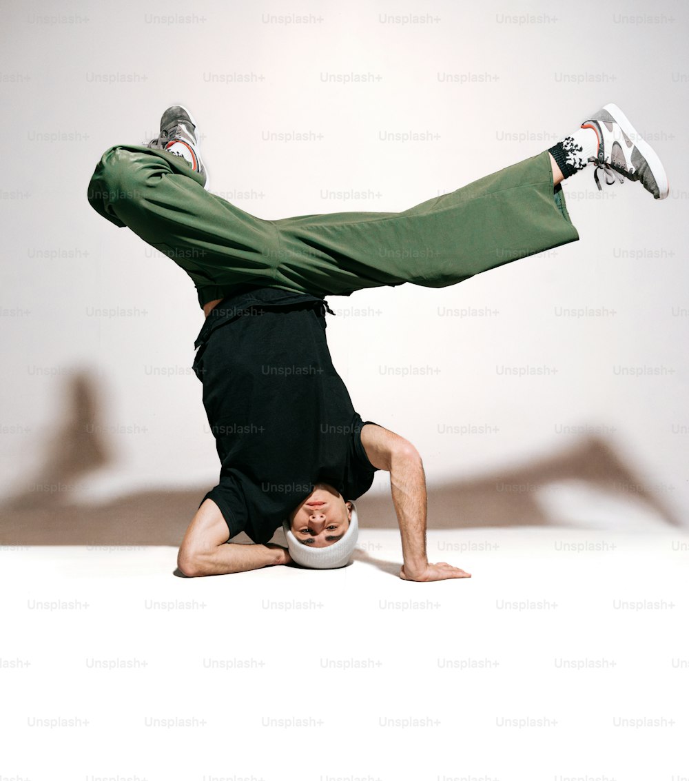 a man doing a handstand on a white surface