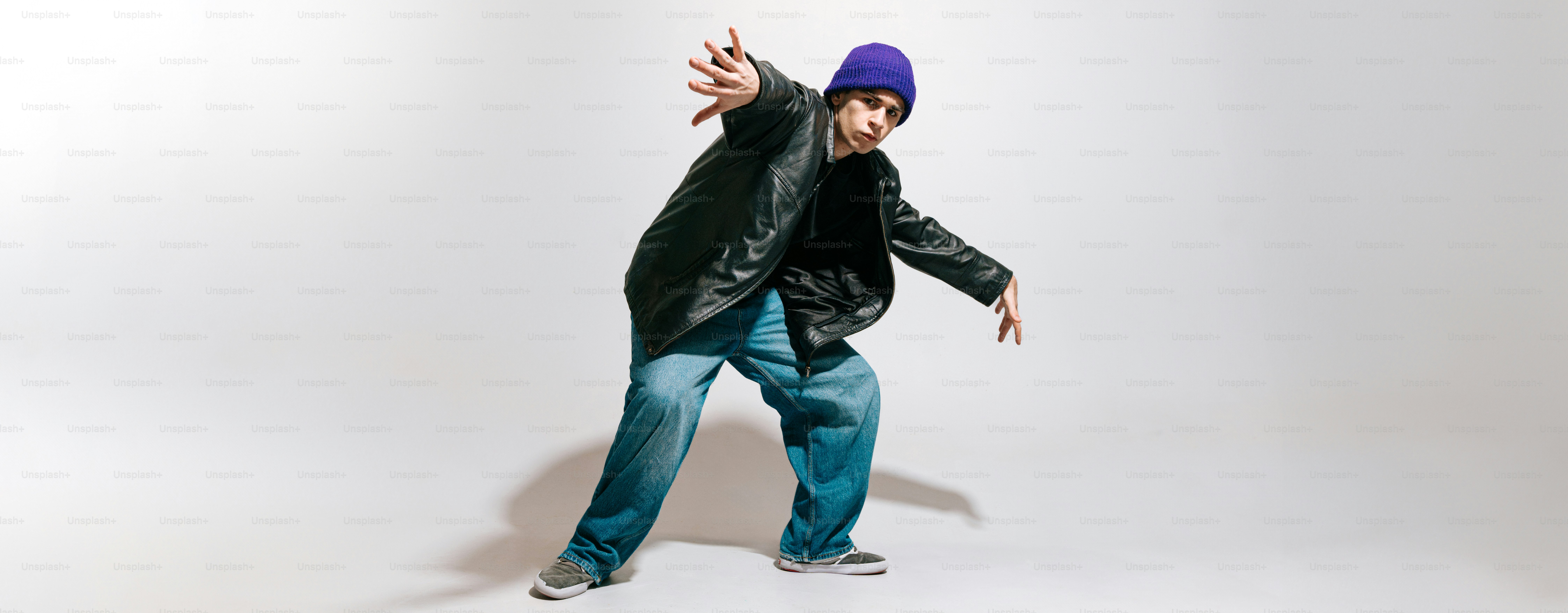 Ein Mann in schwarzer Jacke und lila Hut