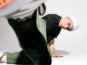 a man in black shirt and green pants doing a handstand