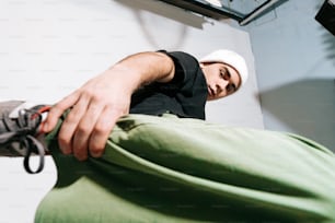 a man in black shirt and white hat laying on a bed