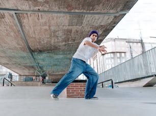 a man in a white shirt and blue jeans is doing a trick on a skate