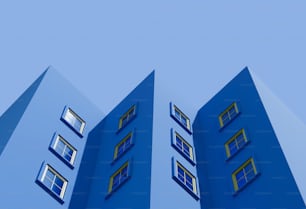 a blue building with three windows and a sky background
