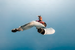 a man flying through the air while riding a snowboard