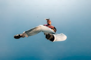 un uomo che vola nell'aria mentre cavalca uno snowboard