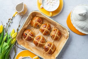 a pan filled with hot cross buns on top of a table