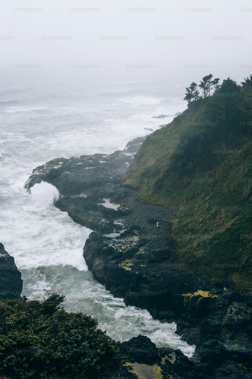 uma pessoa em pé em um penhasco perto do oceano