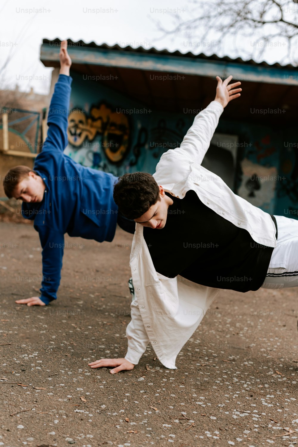 two men doing a handstand on a skateboard