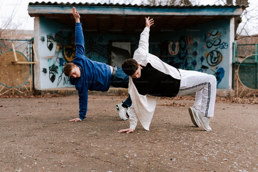 two people doing a handstand in front of a building