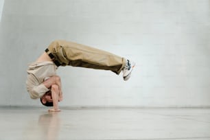 a man is doing a handstand on the floor