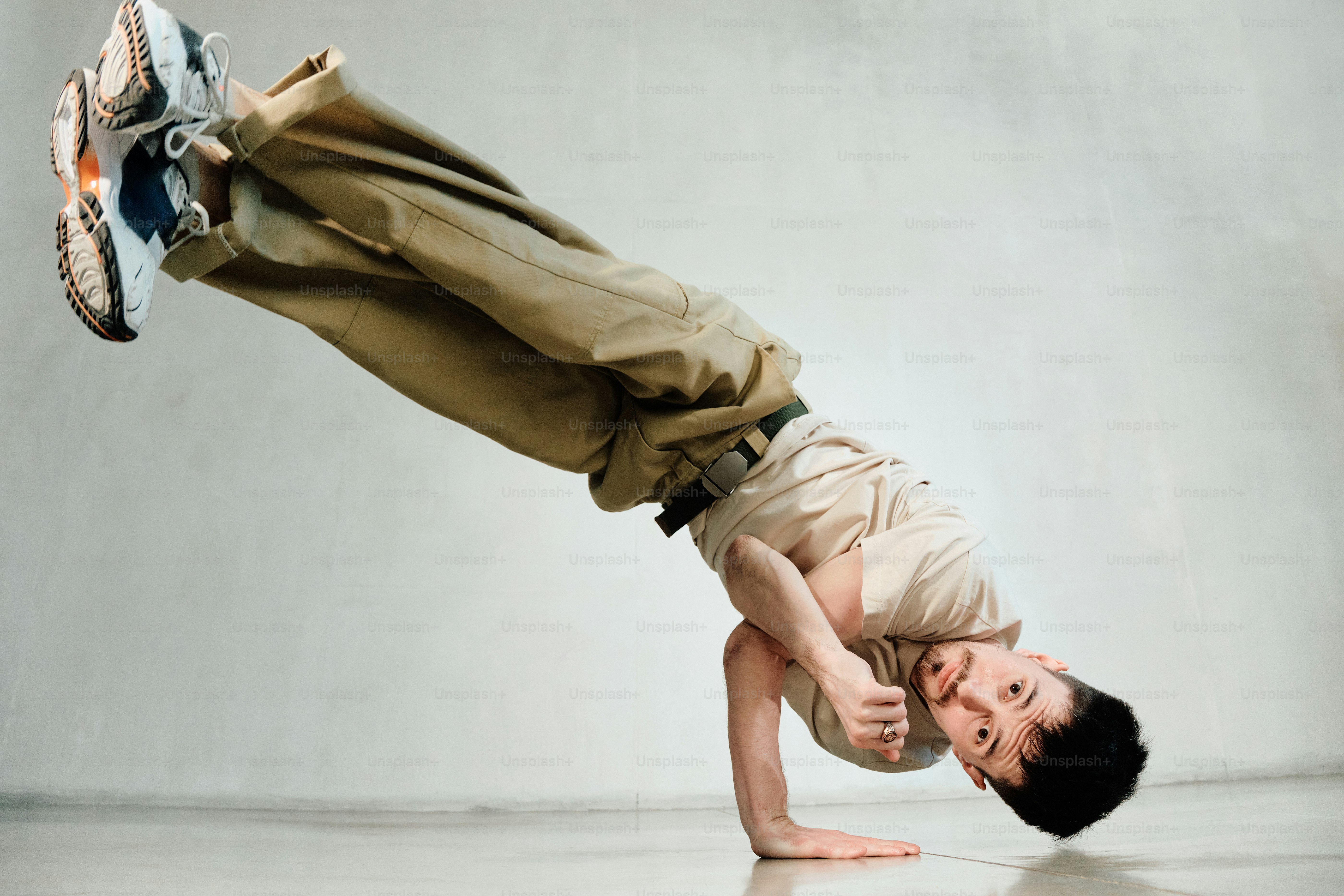 a bboy is practicing breakdancing in the studio