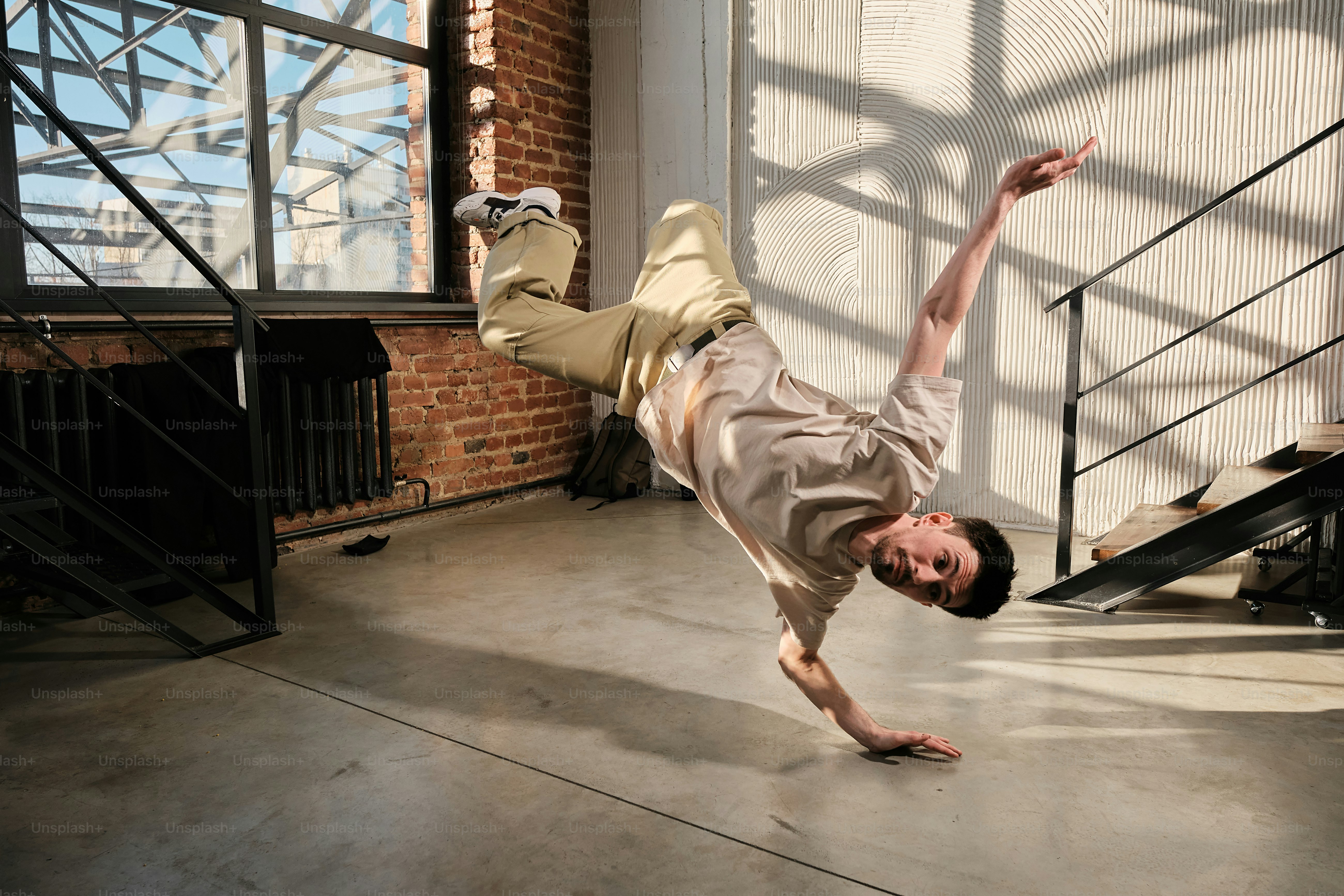A man is doing a handstand on the floor photo – Breakdance Image on ...