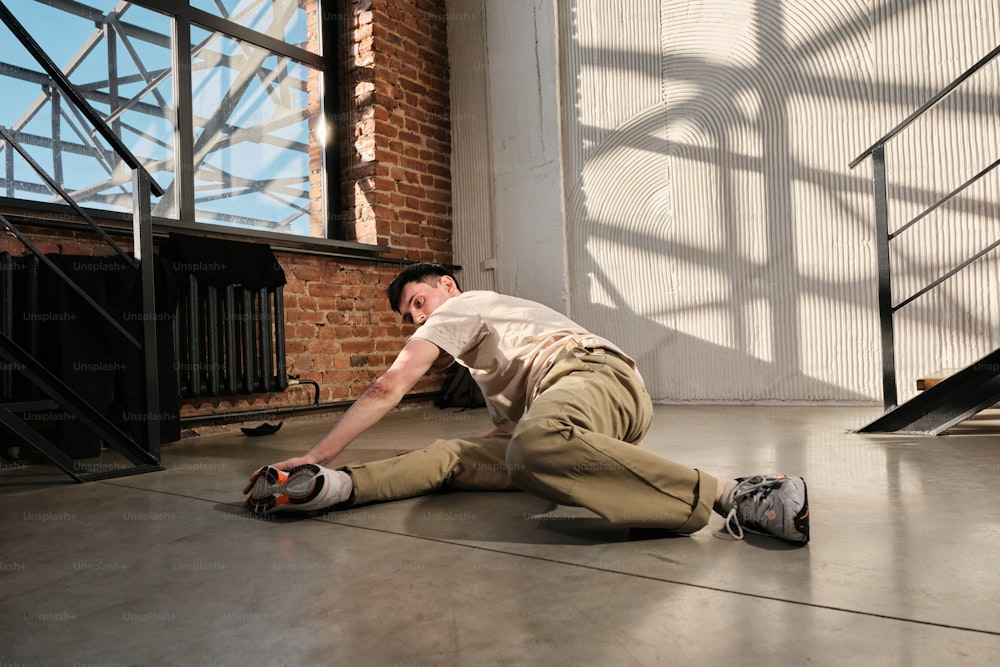 a man laying on the ground in front of a window
