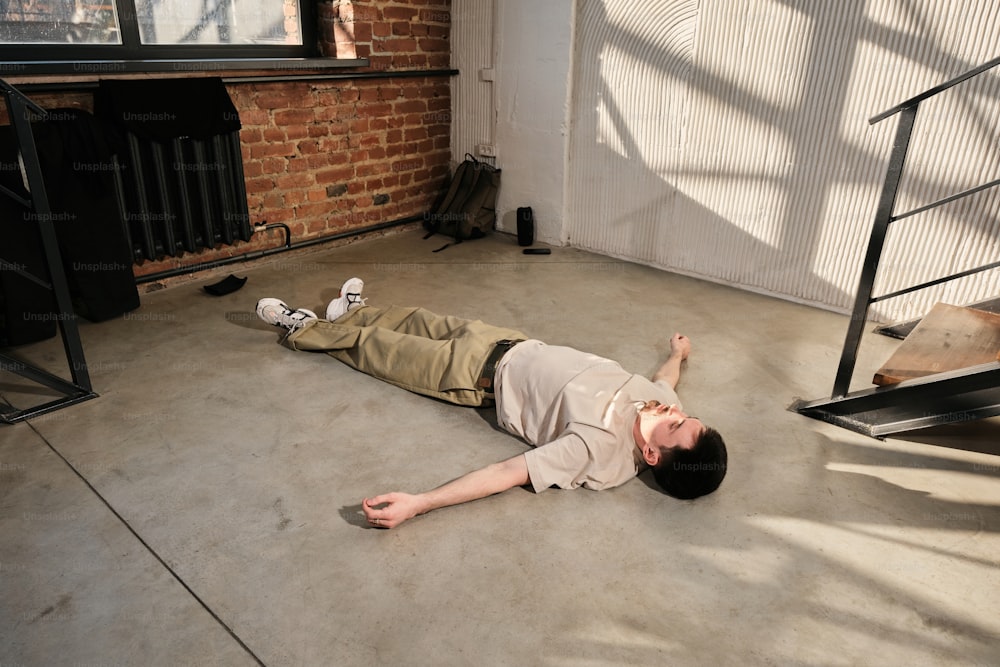 um homem deitado no chão em um quarto