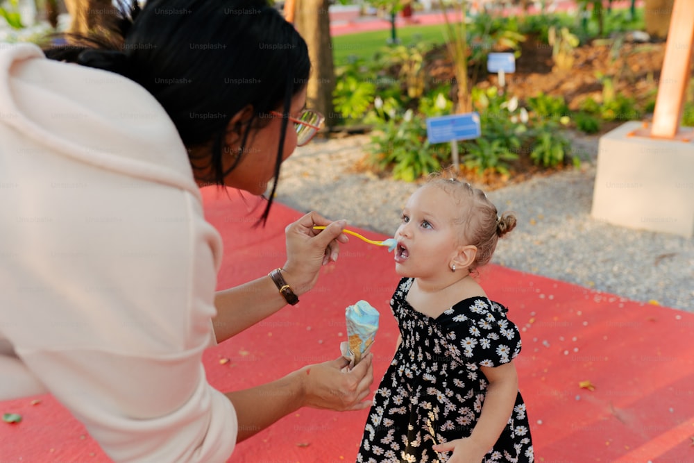 a woman feeding a small child with a spoon