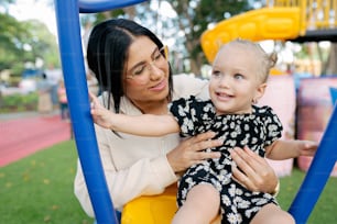 a woman holding a child on a swing