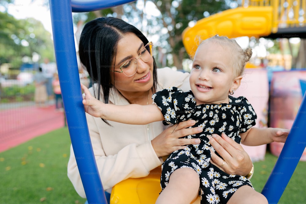 a woman holding a child on a swing