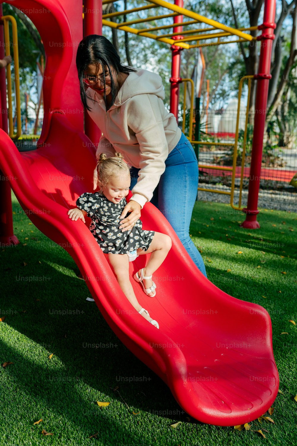 a woman and a child playing on a slide