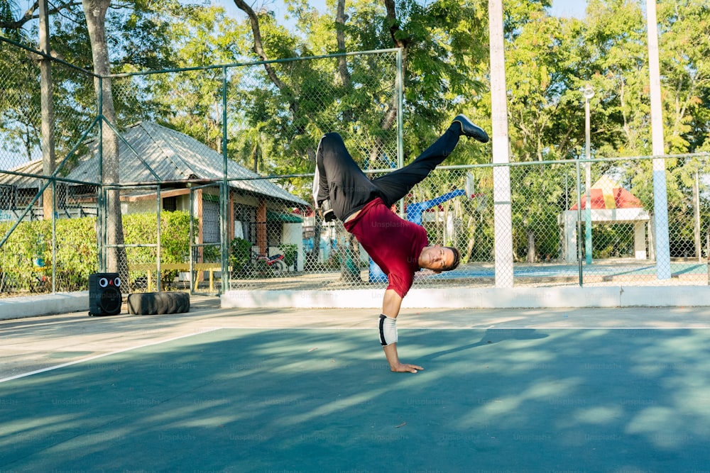a man doing a handstand on a tennis court