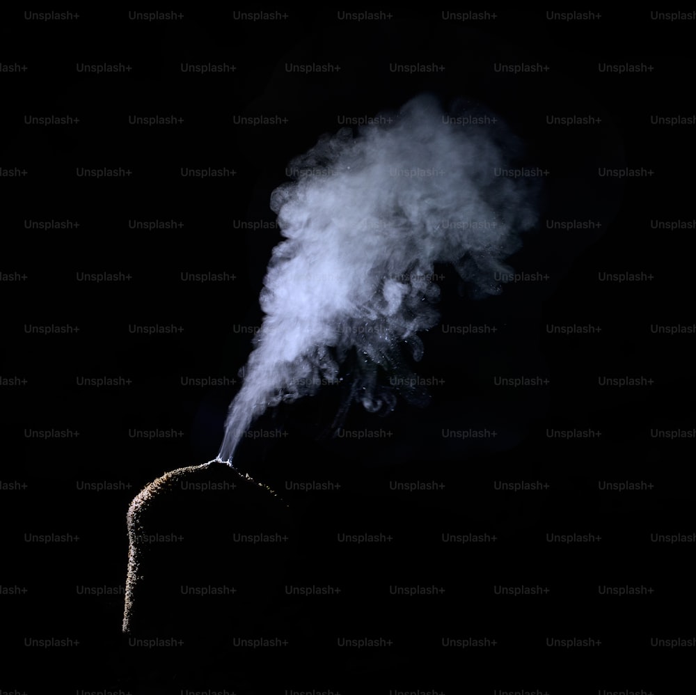 una persona parada en la oscuridad con humo saliendo de su cabeza