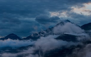 a view of a mountain range covered in clouds