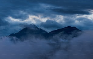 a view of a mountain range covered in clouds