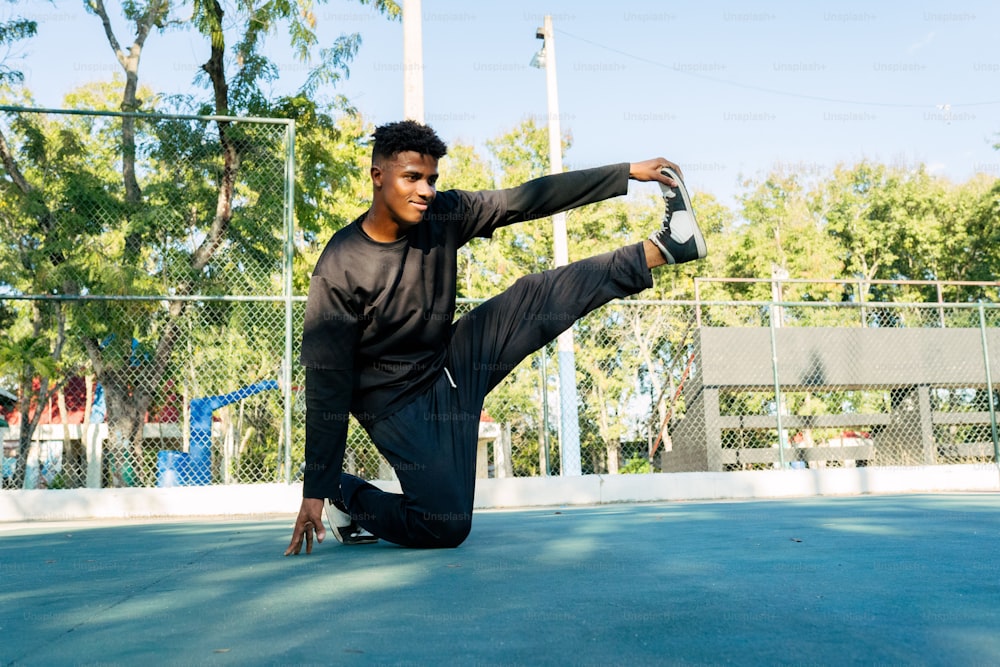 Ein Mann macht eine Kickbox-Pose auf einem Tennisplatz