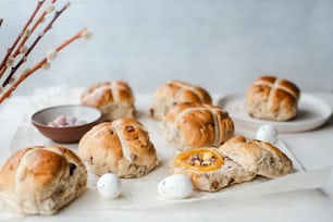 a table topped with hot cross buns and eggs