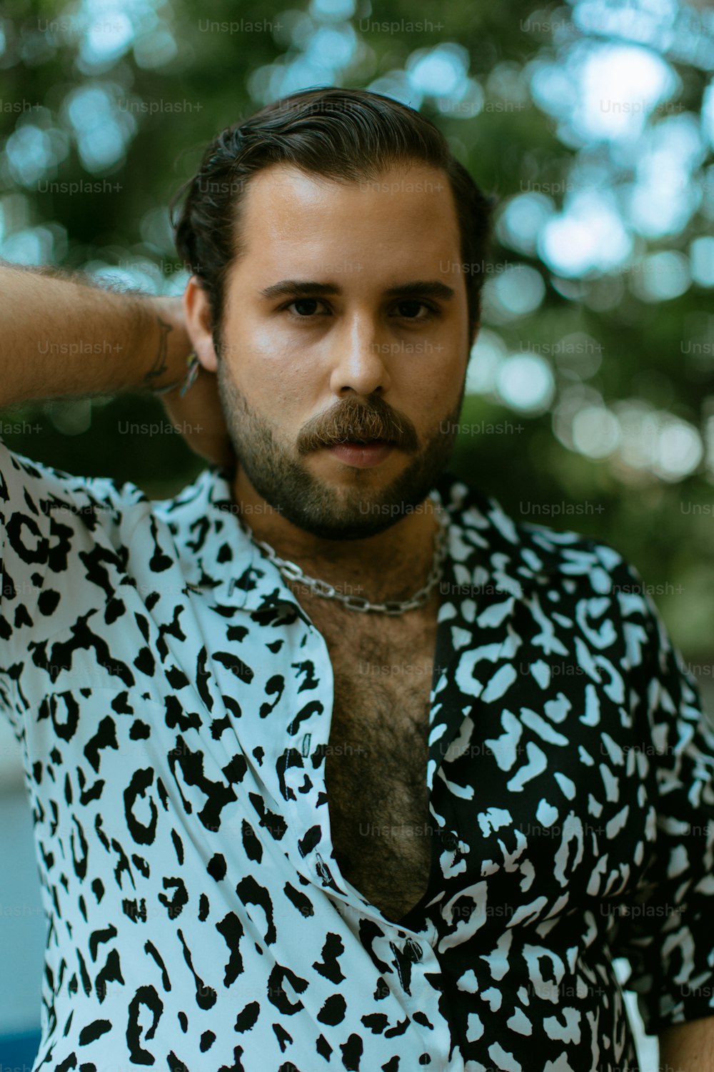Un hombre con barba que lleva una camisa con estampado de leopardo