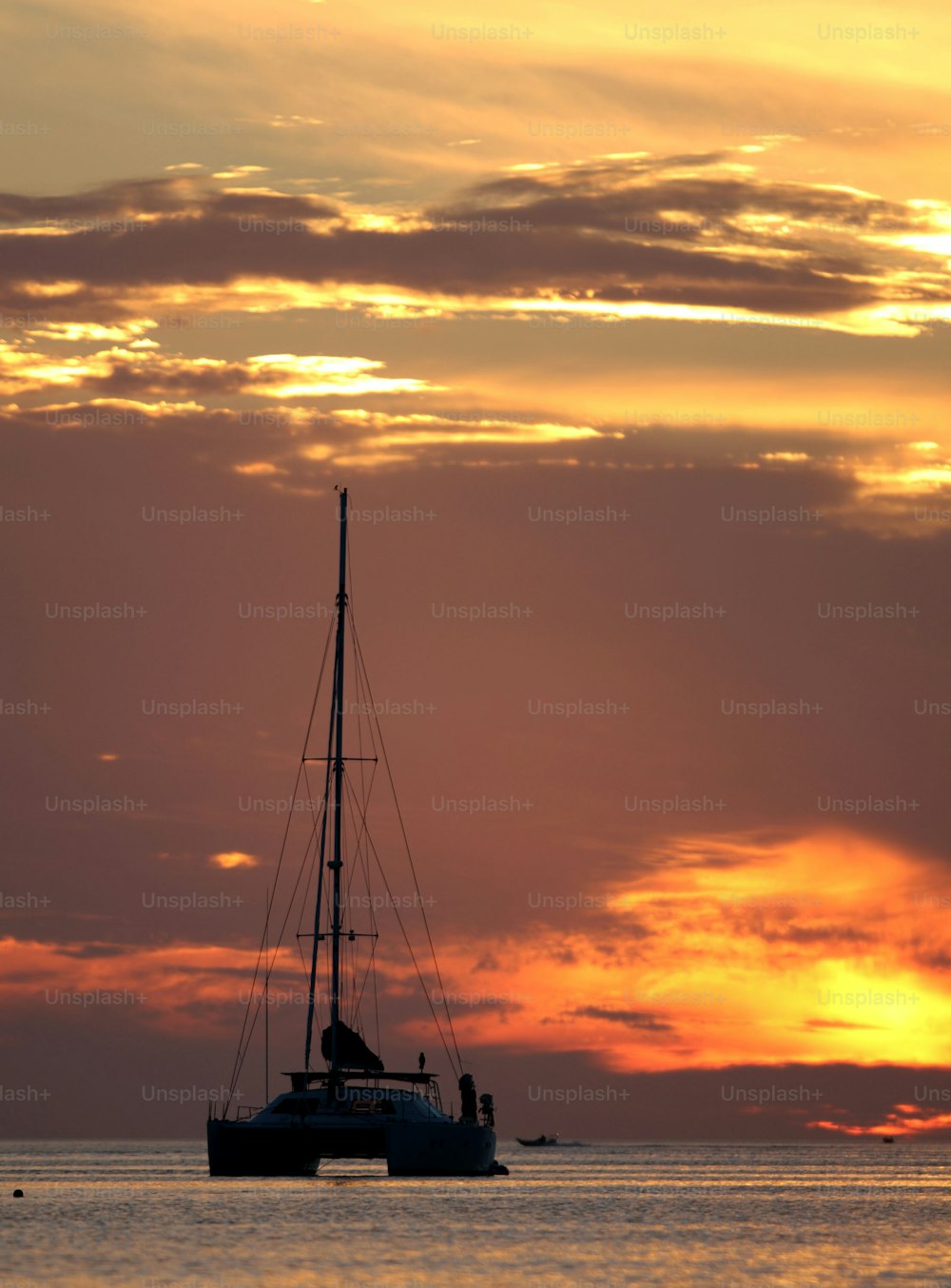 a sailboat in the ocean at sunset