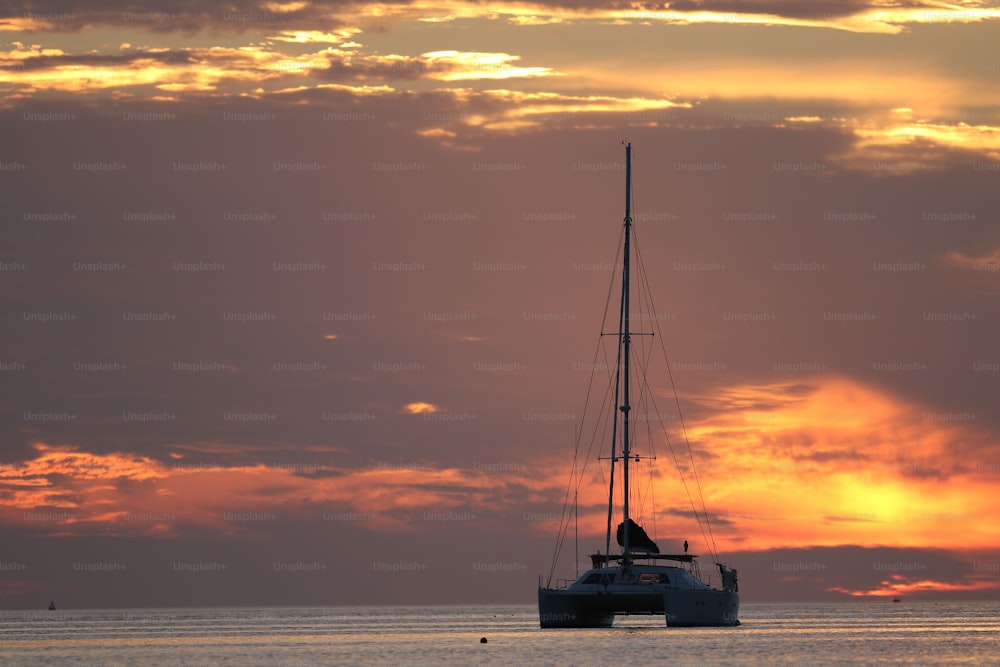 Um veleiro no oceano ao pôr do sol