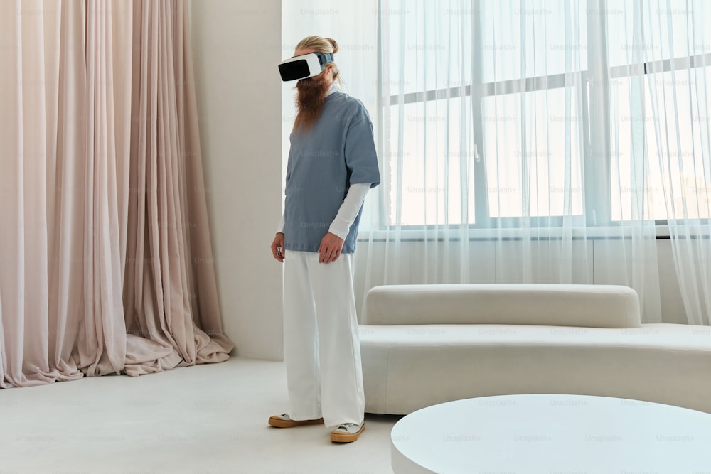 Ein Mann, der mit einem Virtual-Reality-Headset vor einem Fenster steht