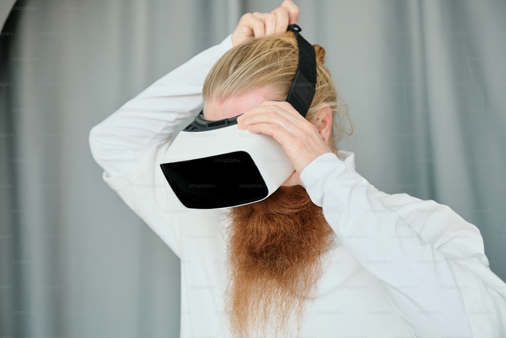 uma mulher com longos cabelos ruivos e uma venda cobrindo os olhos