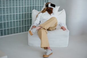 a woman sitting on a white couch wearing a pair of virtual glasses