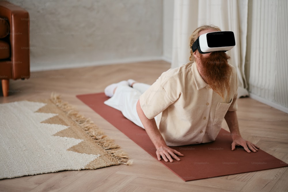 a man sitting on a yoga mat wearing a virtual reality headset
