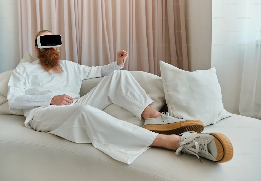 a man sitting on a couch wearing a virtual reality headset