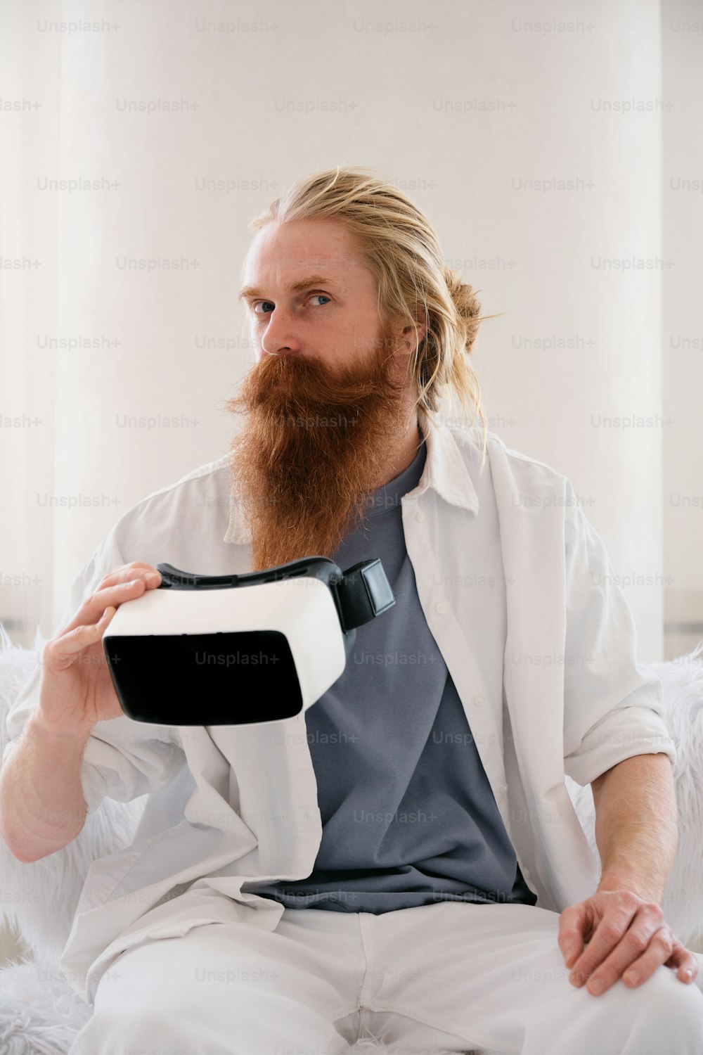 a man with a beard sitting on a bed