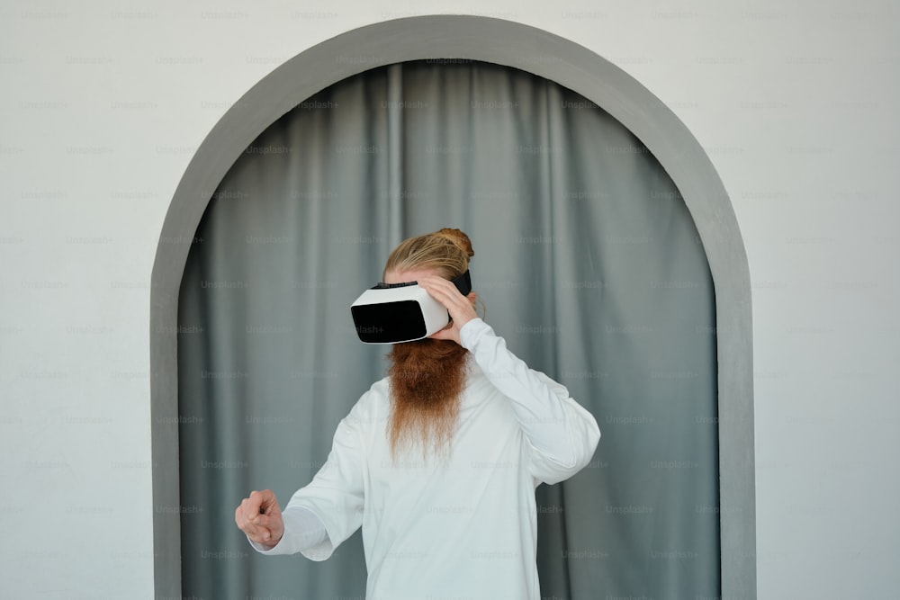 un homme à la longue barbe rousse portant un casque virtuel