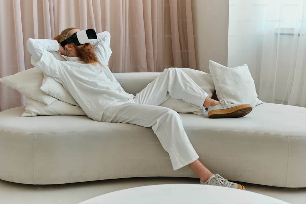 a woman laying on top of a white couch