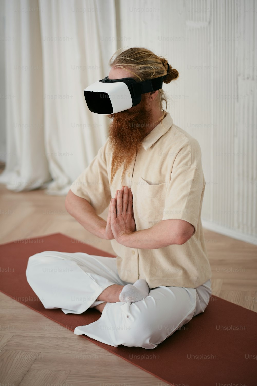 a man with a beard and blindfold sitting on a yoga mat