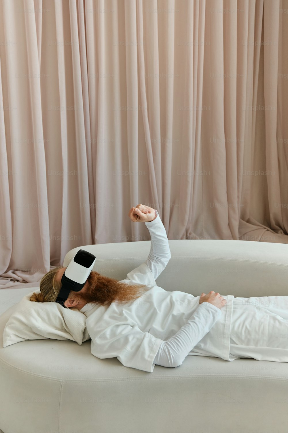 a woman laying on a white couch in a room