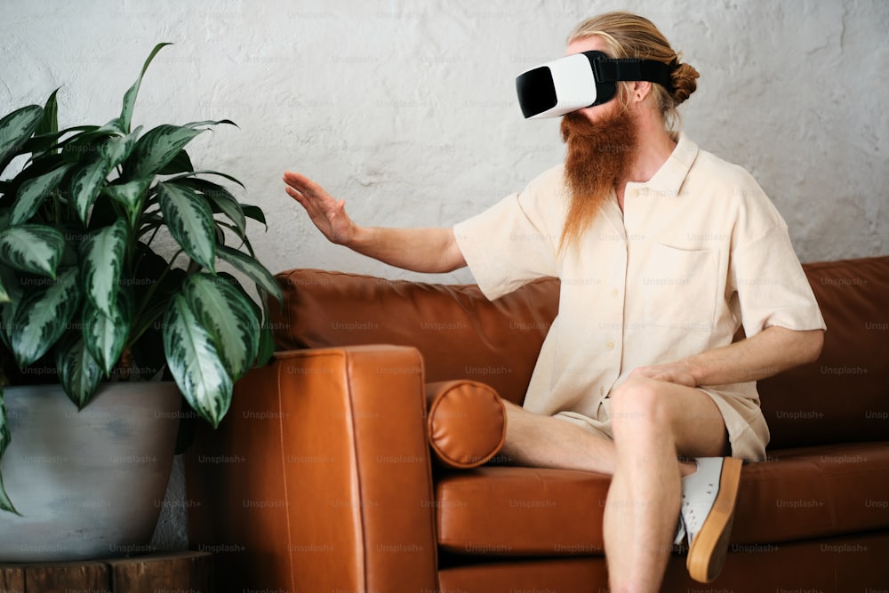 a man sitting on a couch wearing a pair of virtual glasses